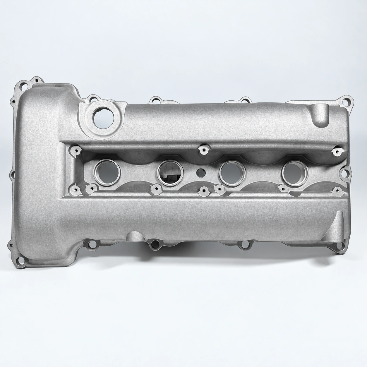 Exterior view of an aluminum engine valve cover with mounting features and assembly openings.
